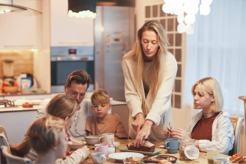 Family breakfast with parents and children at the kitchen table.