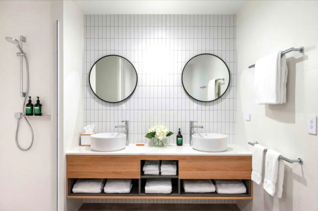 Modern bathroom with dual sinks and round mirrors for stylish renovation.