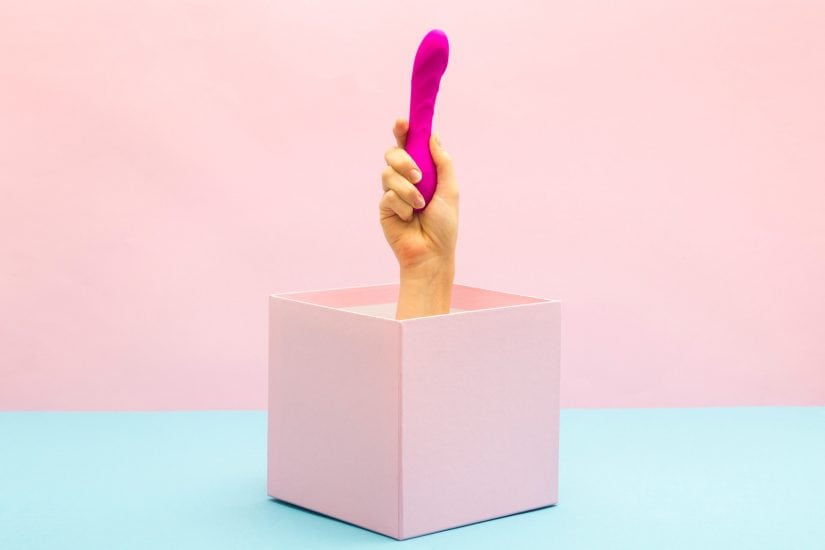 Sexy stocking stuffer in pink held by hand emerging from a pink box.