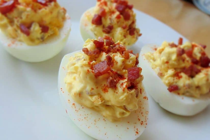 Devilled eggs with sweet chilli and bacon topping for party snacks.