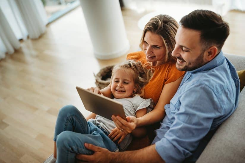 Family using a tablet for entertainment and bonding.