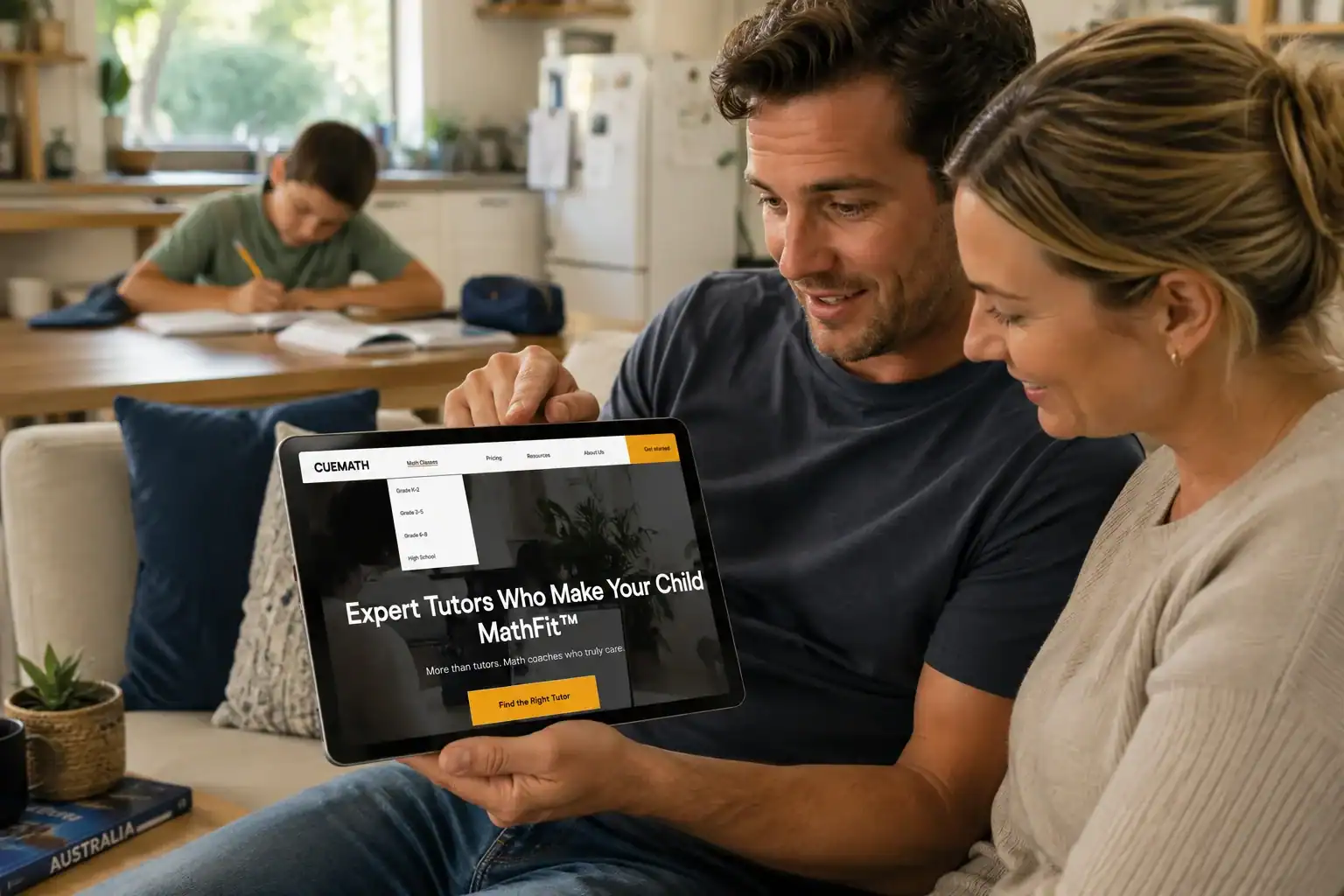 Parent reviewing online maths tutoring program on tablet with child in background.